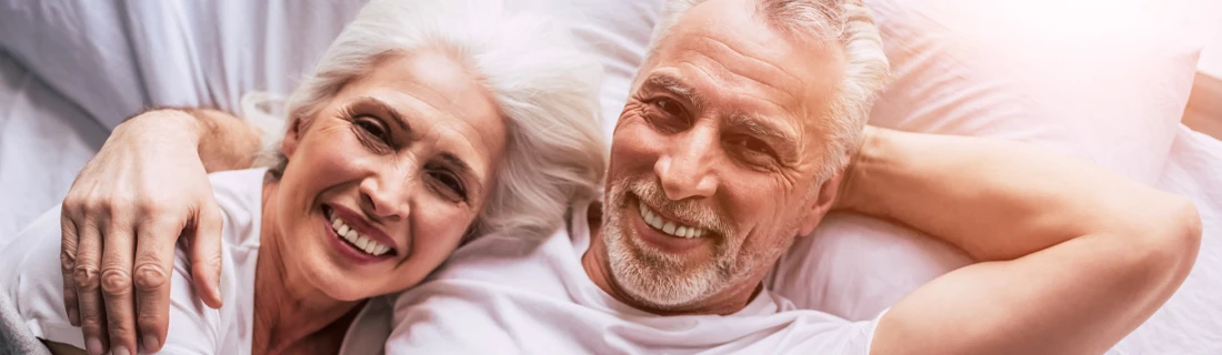 Dentist Chicago IL Older Couple Smiling in Bed Dentist Chicago IL Older Couple Smiling in Bed